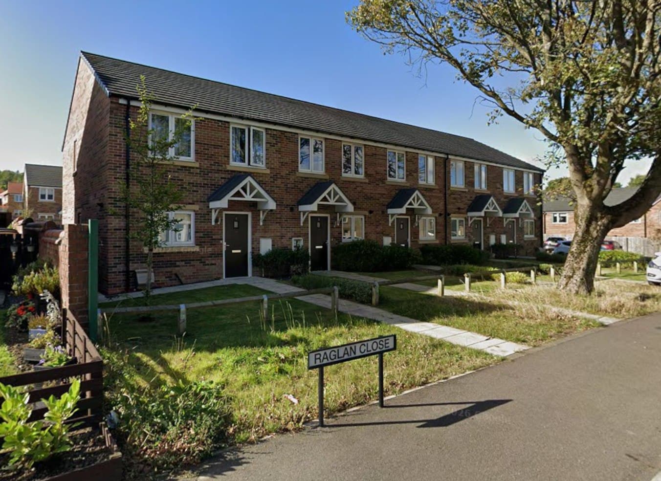 Annfield Plain, County Durham: brick-built terrace of homes at Raglan Close with pitched-canopy porches and front lawns, Karbon Homes affordable scheme