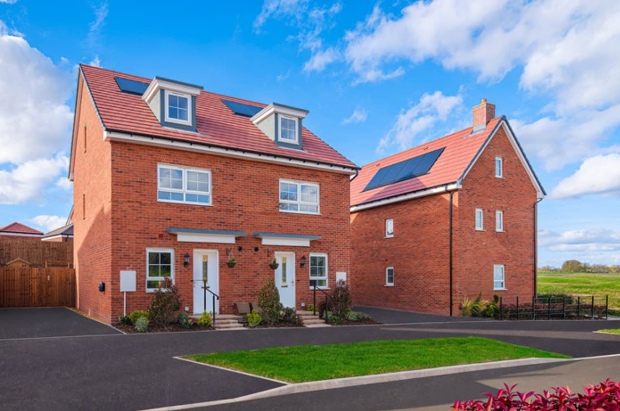 Barlestone, Leicestershire: completed new-build homes in red brick with rendered detailing and dormer windows, landscaped lawns and a paved drive under a blue sky, Midland Heart affordable scheme