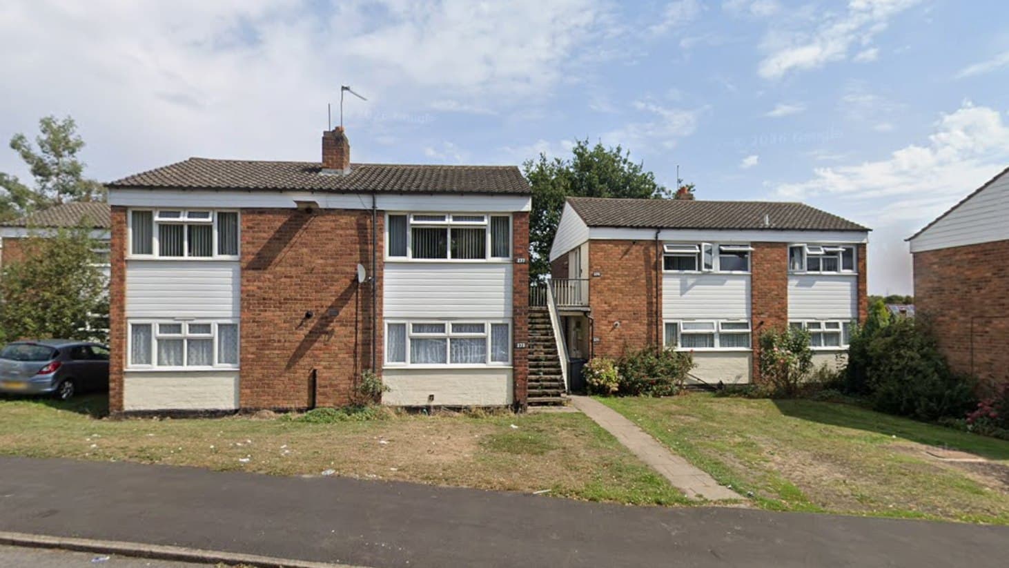 Beaconview Road, West Bromwich: two-storey brick maisonette blocks with white cladding panels and an external access stair, set behind open lawns, Accord Housing affordable scheme