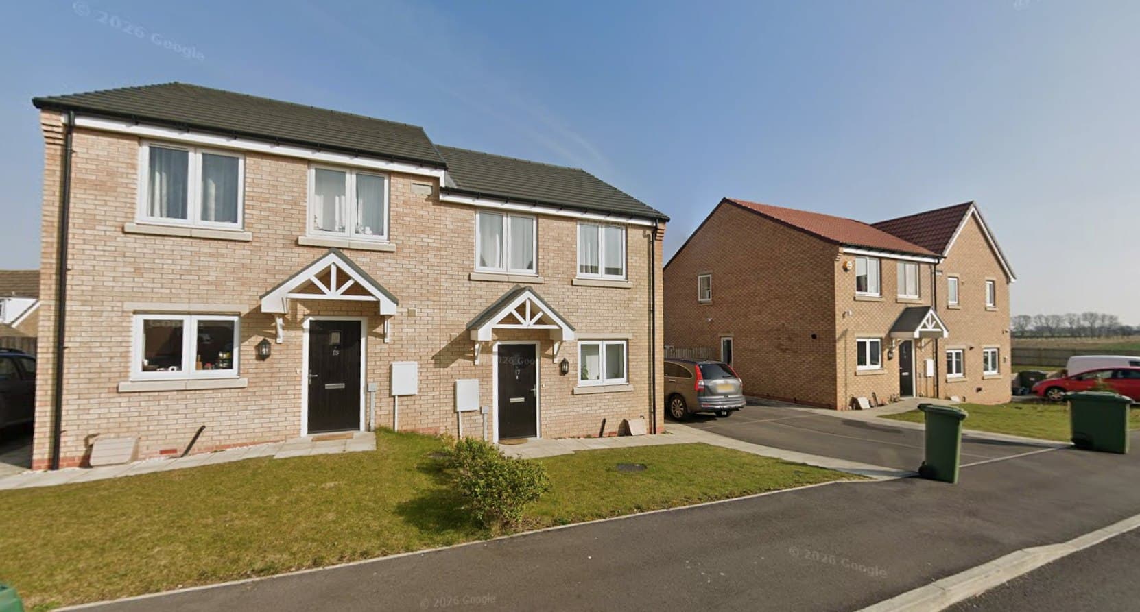 Coates Avenue, Winterton: completed semi-detached new-build homes in buff and red brick with canopy porches and white windows, further homes and open countryside beyond, Ongo Homes affordable scheme