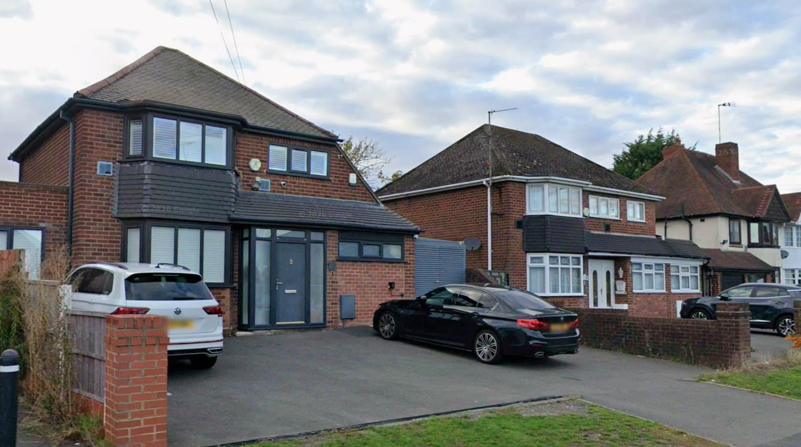 Oldbury Road, Worcester: contemporary detached home in red brick with dark-grey cladding and anthracite windows beside the street, neighbouring 1930s semis to the right, Platform Housing Group scheme