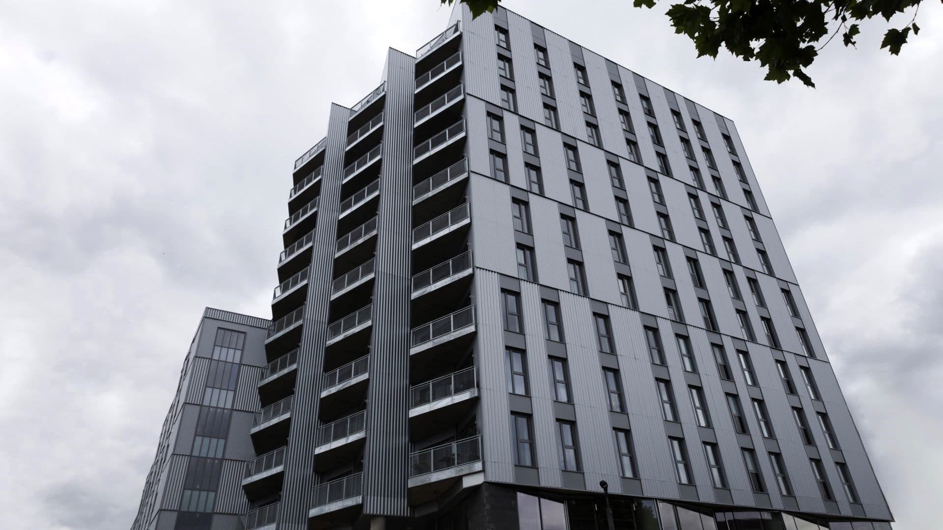 Burnt Oak Broadway, Barnet: silver-clad mid-rise tower with vertical balcony array, completed Barnet Homes scheme