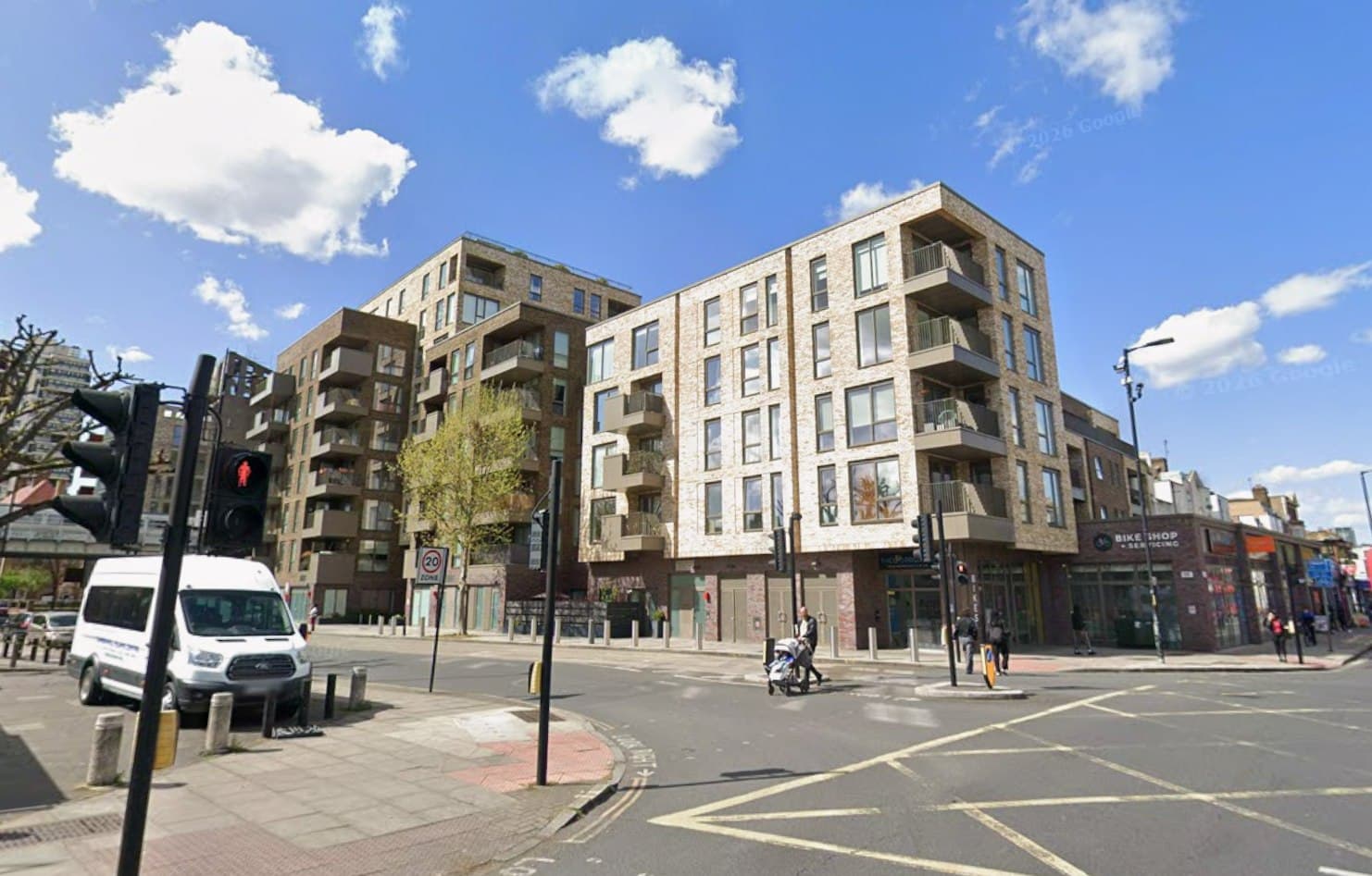 Camberwell Road (166 to 176a), London SE5: street view of the pale-brick residential blocks above ground-floor units, with traffic signals and the Camberwell streetscape in the foreground, A2Dominion scheme