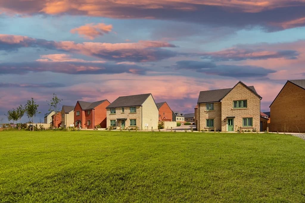 Glenvale Park, Wellingborough: completed detached homes at sunset across a green field foreground, 148-home Stonewater scheme