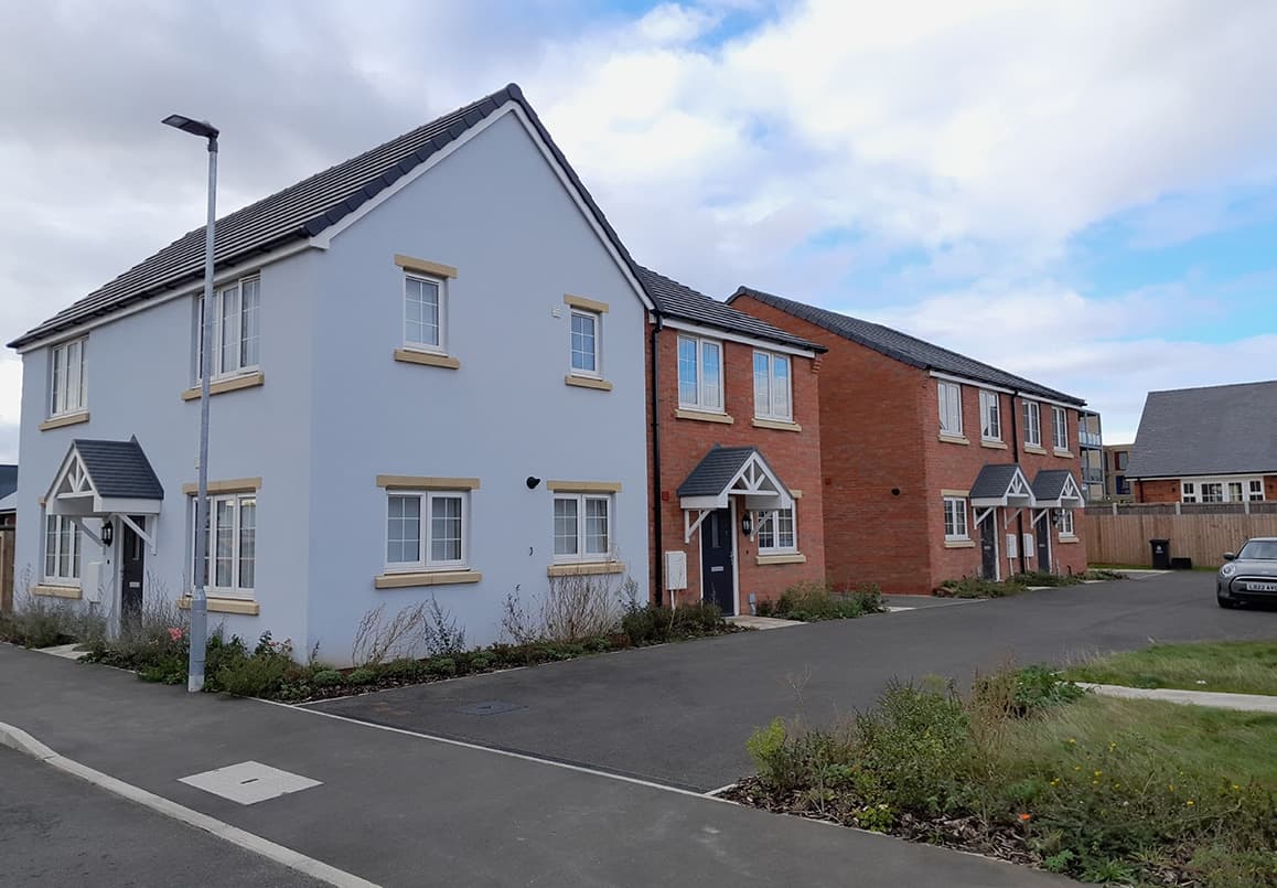 Wheater's Meadow, Walton-on-the-Naze: completed pale-blue render and red-brick detached homes lining the street
